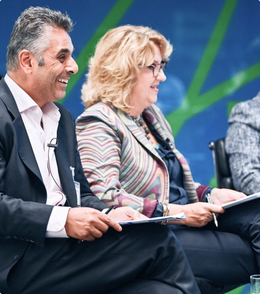 A man and woman from Nedonboard sitting on a chair, smiling at each other.