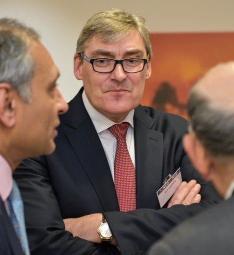 Three businessmen in formal attire engaged in a conversation, exchanging ideas and opinions, reflecting collaboration and professional interaction at Nedonboard.