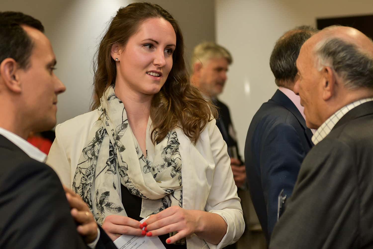 A woman discussing with a man at a Nedonboard social gathering.