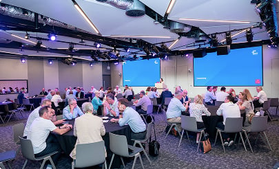 Many groups sitting in a seminar room for dicussion