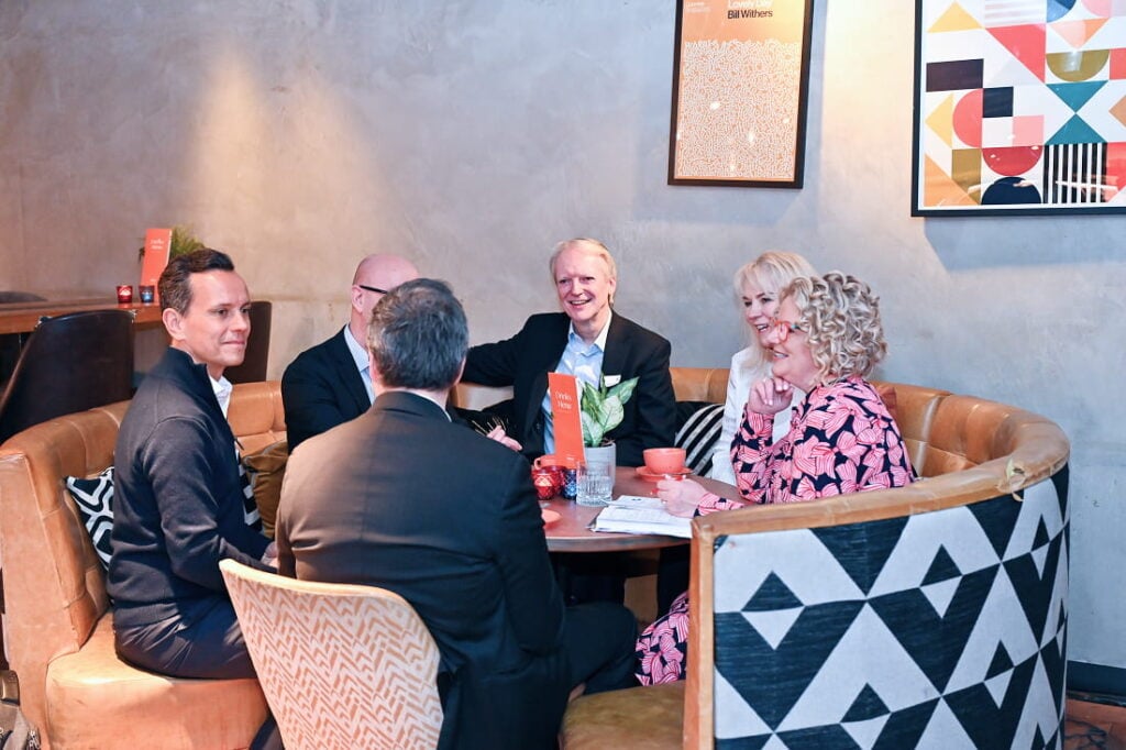A group of individuals seated around a table, engaged in conversation