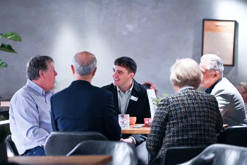 A group of people sitting in a round table conference